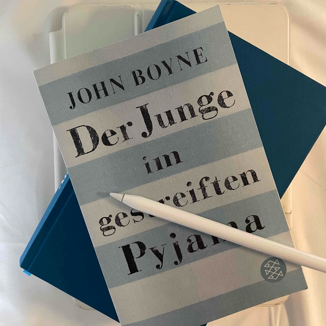 »›Die Zugfahrt war schrecklich‹, sagte Schmuel. ›In den Waggons waren zu viele Menschen. Wir hatten kaum Luft zum Atmen. Und es roch entsetzlich.‹
›Weil ihr euch alle in einen Zug gezwängt habt‹, sagte Bruno und erinnerte sich an die beiden Züge, die er bei der Abfahrt aus Berlin gesehen hatte. ›Als wir hierher kamen, stand noch einer auf der anderen Seite des Bahnsteigs, aber den schien keiner zu sehen. In den sind wir gestiegen. Den hättet ihr auch nehmen sollen.‹
 ›Ich glaube nicht, dass wir das gedurft hätten‹, sagte Schmuel und schüttelte den Kopf. ›Wir konnten unseren Waggon nicht verlassen,‹
›Die Türen sind am Ende‹, erklärte Bruno. […] ›Natürlich waren da welche.‹«

