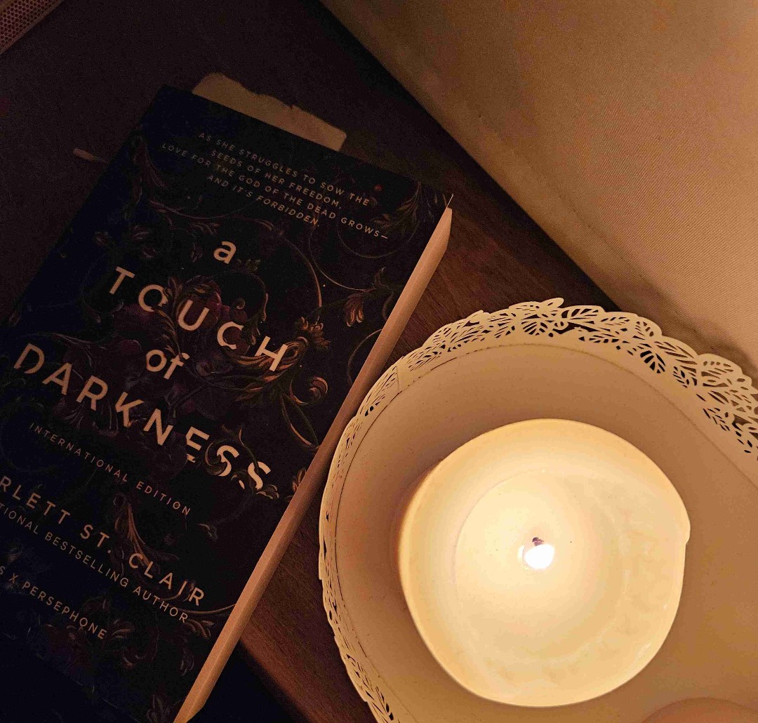 A Touch of Darkness is a modern retelling of the Hades and Persephone myth, set in a world where gods walk among mortals. When Persephone makes a dangerous deal with Hades, she must navigate love, power, and her hidden magic—or risk losing everything.